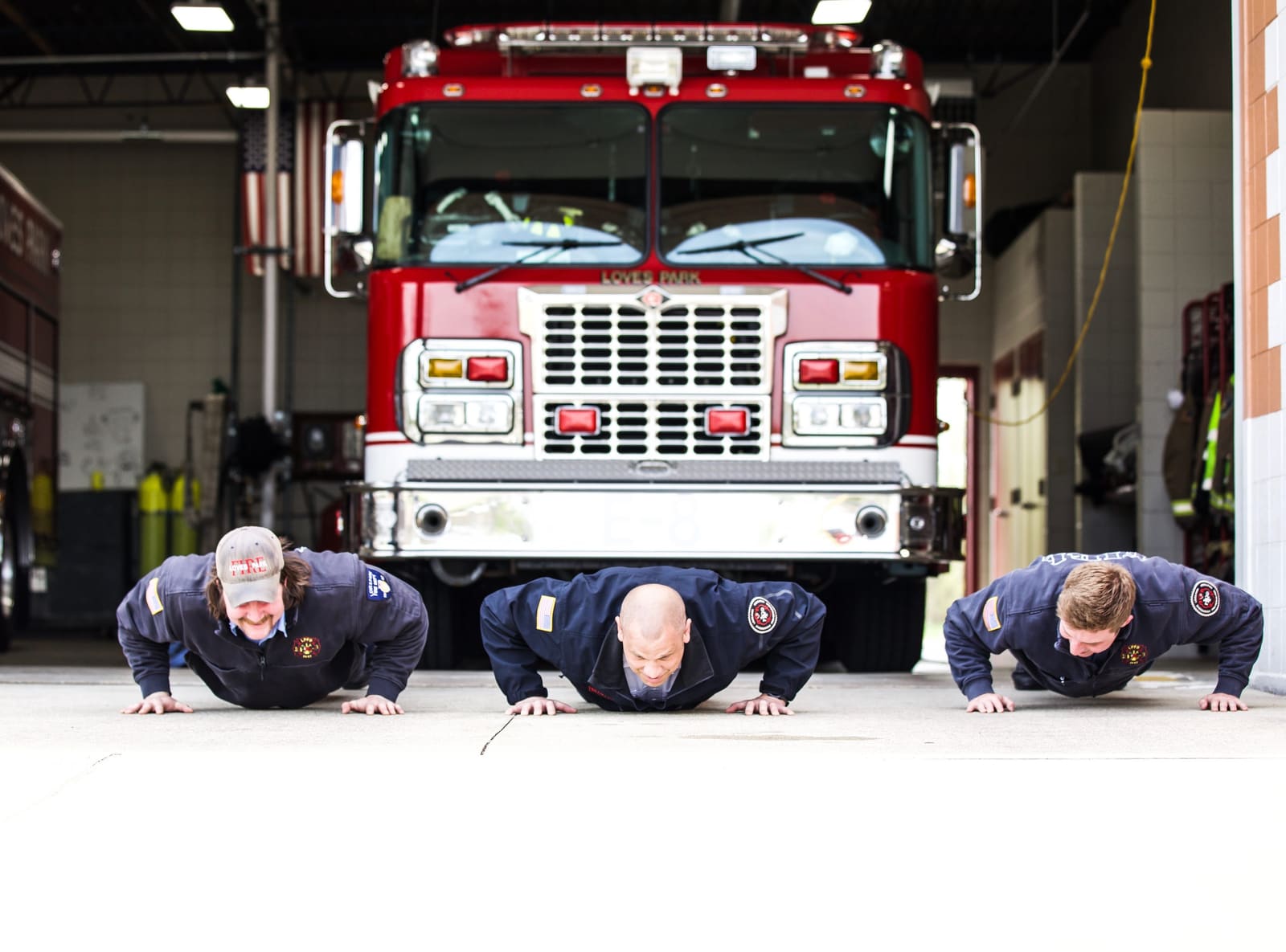 Firefighters performing pushups during first responder training at OAK STRENGTH in Loves Park